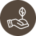 White icon of a hand holding soil with a small sprouting plant, set against a brown circular background.